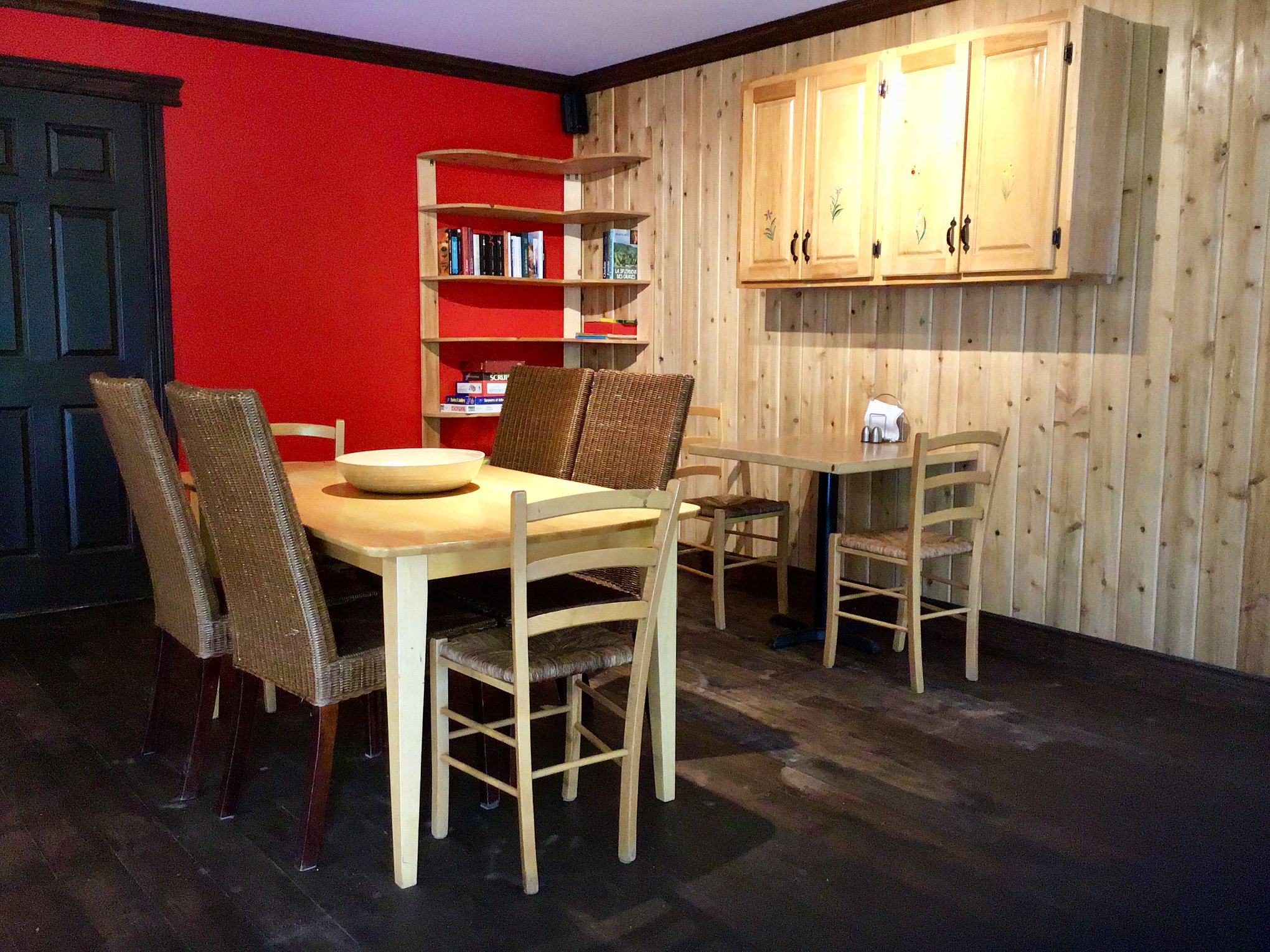 La salle à manger du chalet, murs de pin et mur rouge