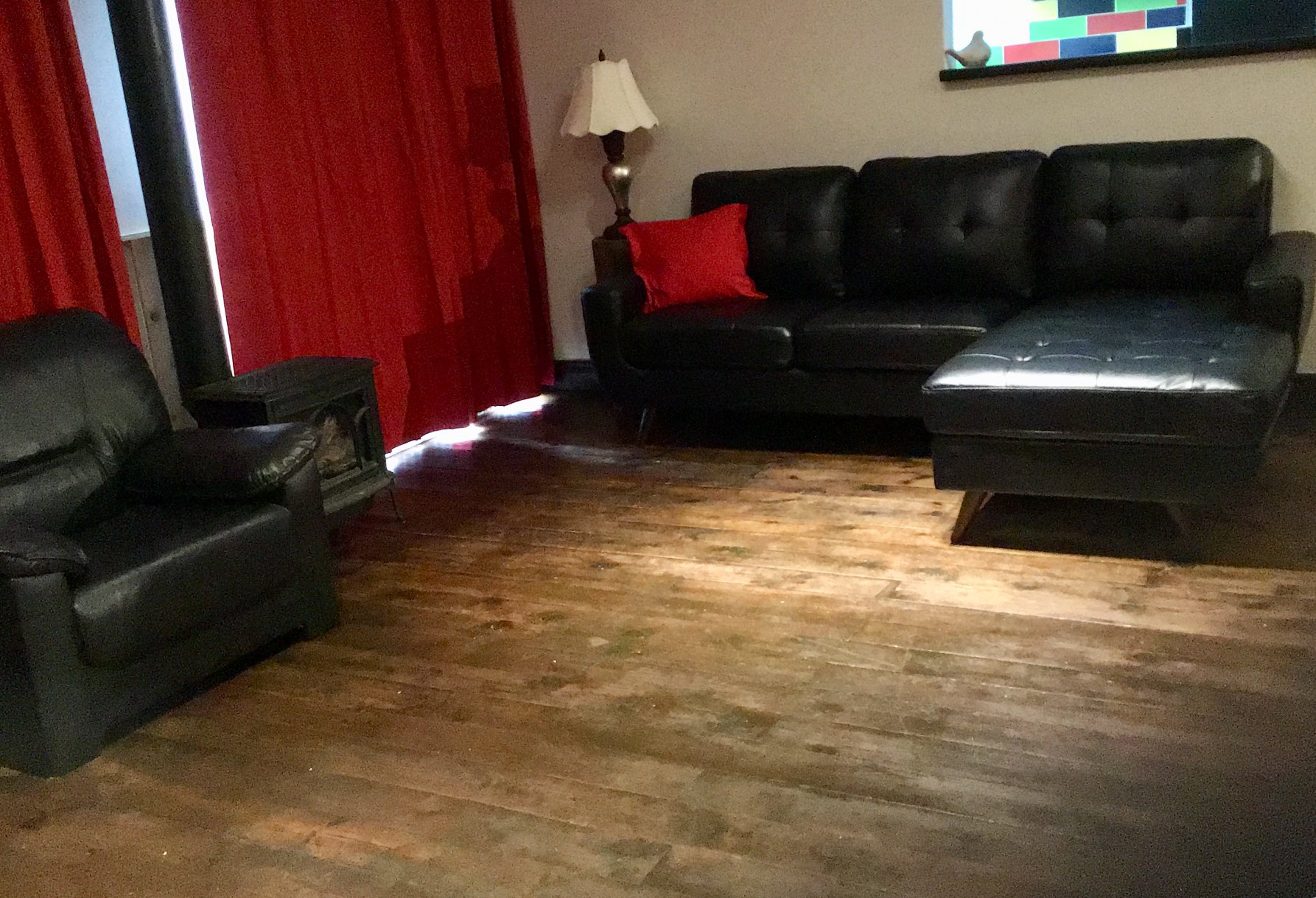 Le salon du chalet avec ses fauteuils et son canapé en cuir noir